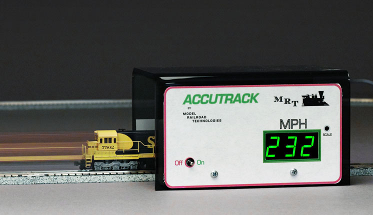 Running N scale trains too fast: An image of an N scale locomotive passing through an accutrak speedometer which reads "232 MPH"