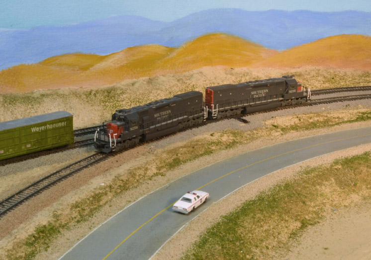 My first model railroad operating session: An image of an A/B set of model locomotives alongside a road with model vehicles