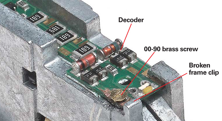 An image of a N scale decoder, with labels pointing to Decoder, 00-90 brass screw, and broken frame clip