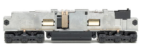 The dual-flywheel motor is isolated from the locomotives split metal frame. Two metal tabs extend down to the motor from the lighting board
