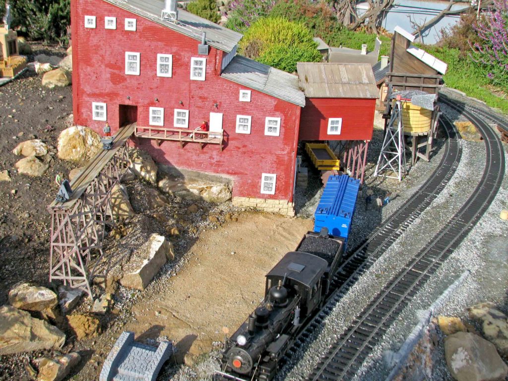 red structure with model train passing by