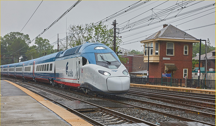 Blue and white high speed train passes tower