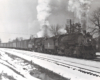 A black and white photo of a steam locomotive on a snowy day