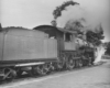 A black and white photo taken from behind a  2-6-0 Mogul-type locomotive on the tracks