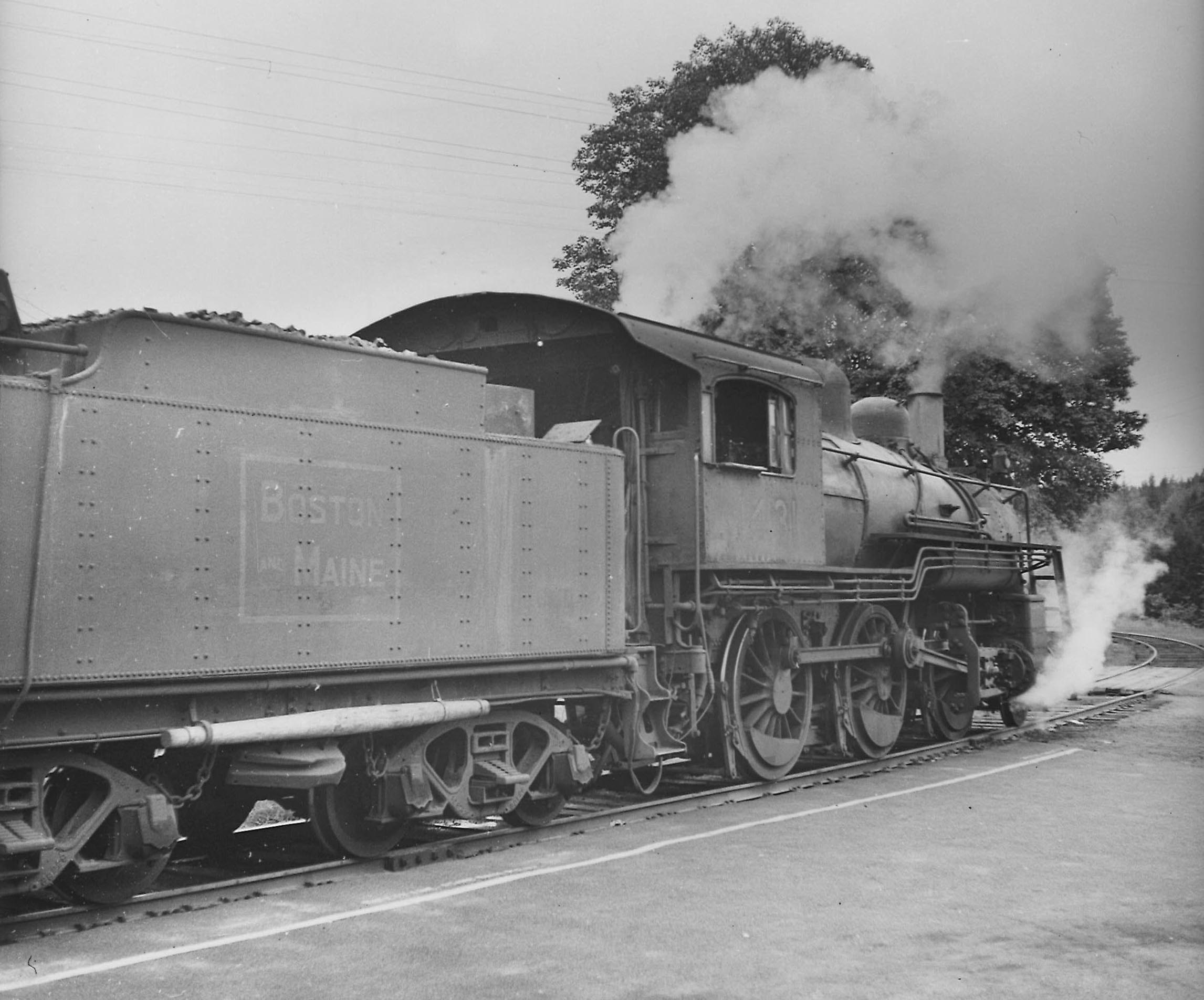 A black and white photo taken from behind a  2-6-0 Mogul-type locomotive on the tracks