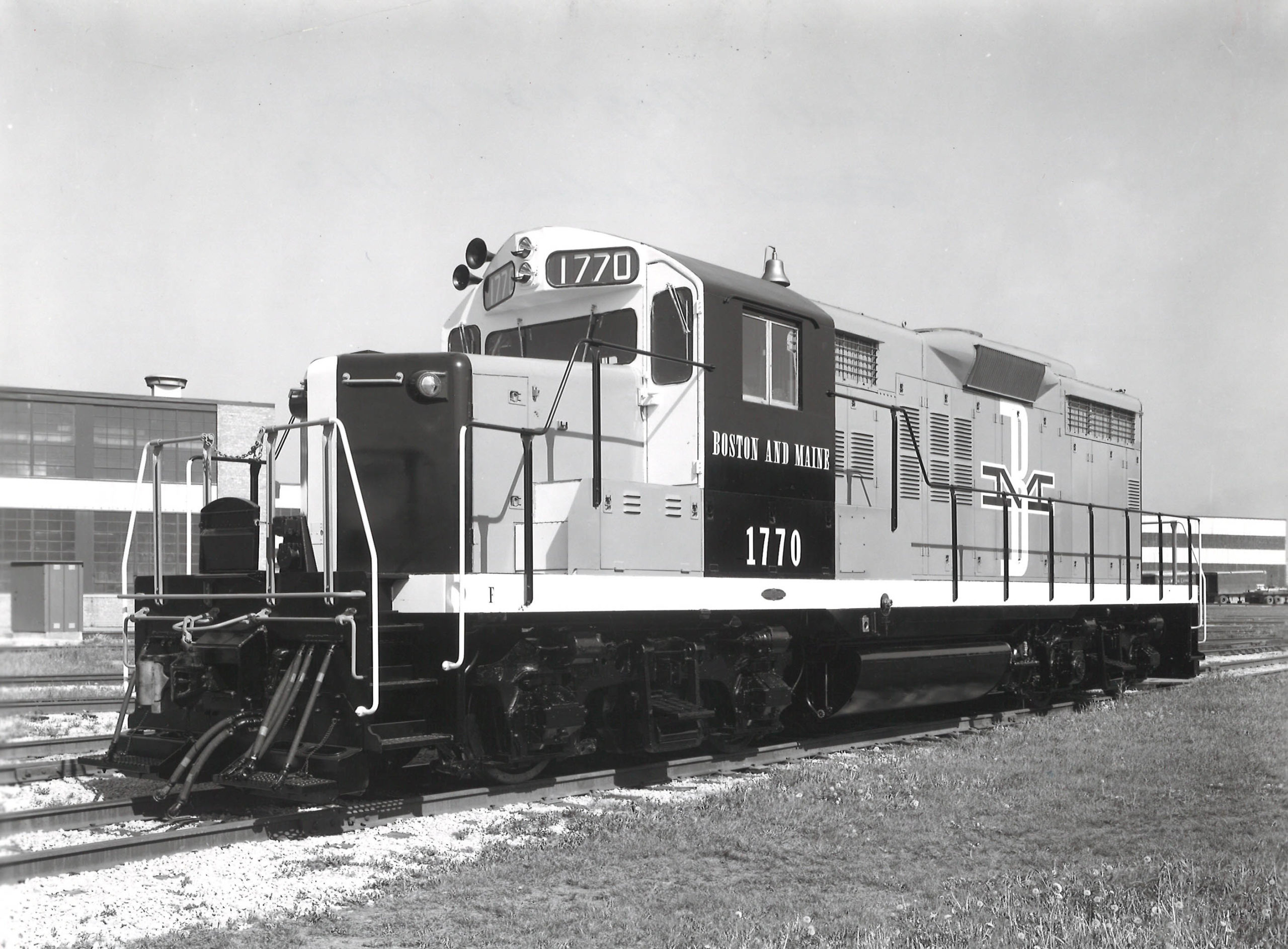 A black and white photo of a EMD locomotive sitting on the tracks