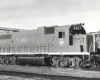 A black and white photo of a EMD locomotive sitting on the tracks