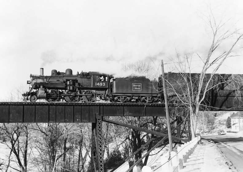 Boston & Maine Mogul-type 2-6-0 No. 1493 crosses the Nashua River bridge at Clinton, Mass., with a suburban train from Boston in January 1956.