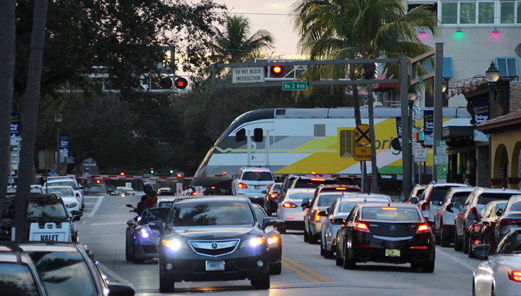 Cars and train at grade crossing with gates down and flashing lights