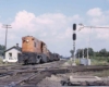 Orange center cab locomotive approaching diamond crossing