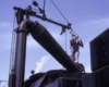 Workman fills steam locomotive water with spout