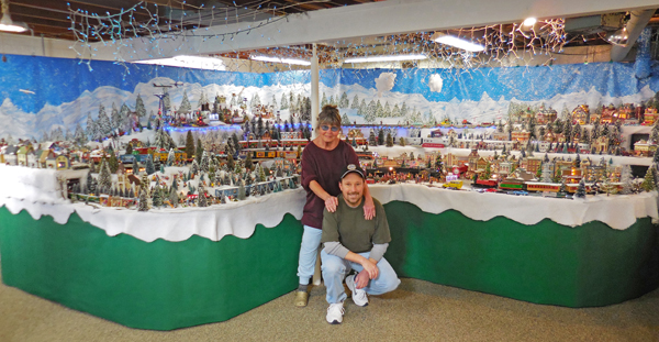 man and woman next to train layout
