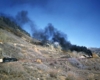 A distant shot of a train traveling through the mountains