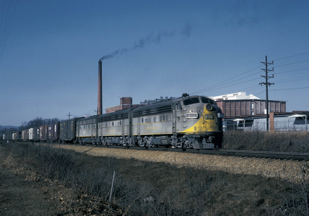 Southbound manifest train 26, three F unit diesels, pauses by the Borden Textile Mill in Kingsport, Tennessee, in March 1967 to add a three-unit rear-end pusher for the 42-mile climb to Erwin.