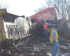 Workers examining a derailed train