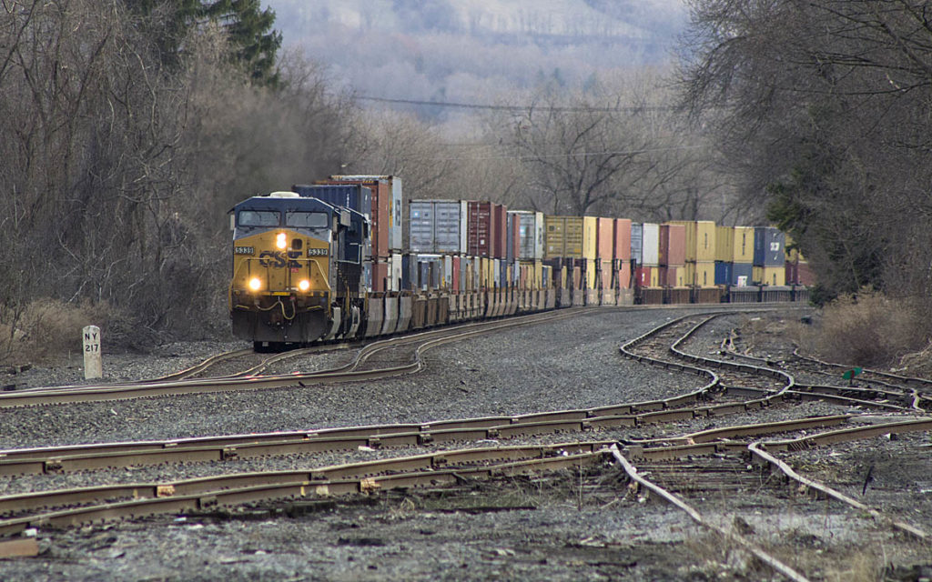 Yellow-and-blue diesel locomotive with containers on curve