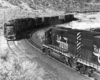 A black and white photo of two diesel locomotives passing each other on the tracks