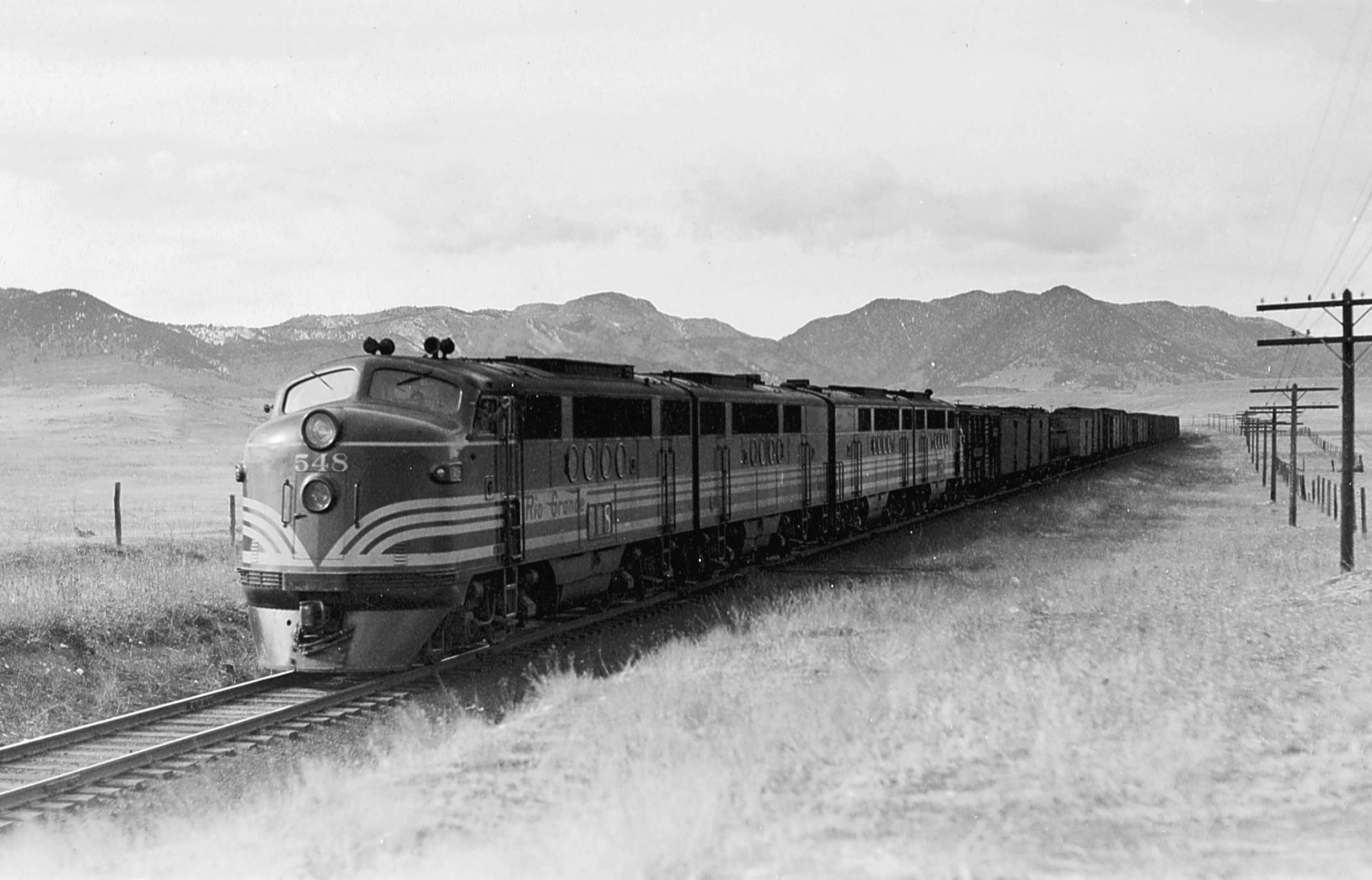A black and white photo of a diesel locomotive on the tracks