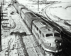 A black and white diesel locomotive on the tracks on a snowy day