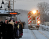 Passengers waiting outside in the snow for a train