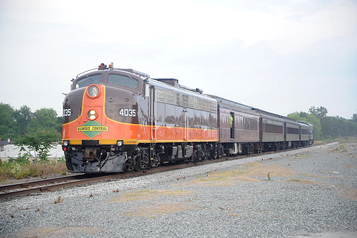 A brown and orange train coming down the tracks