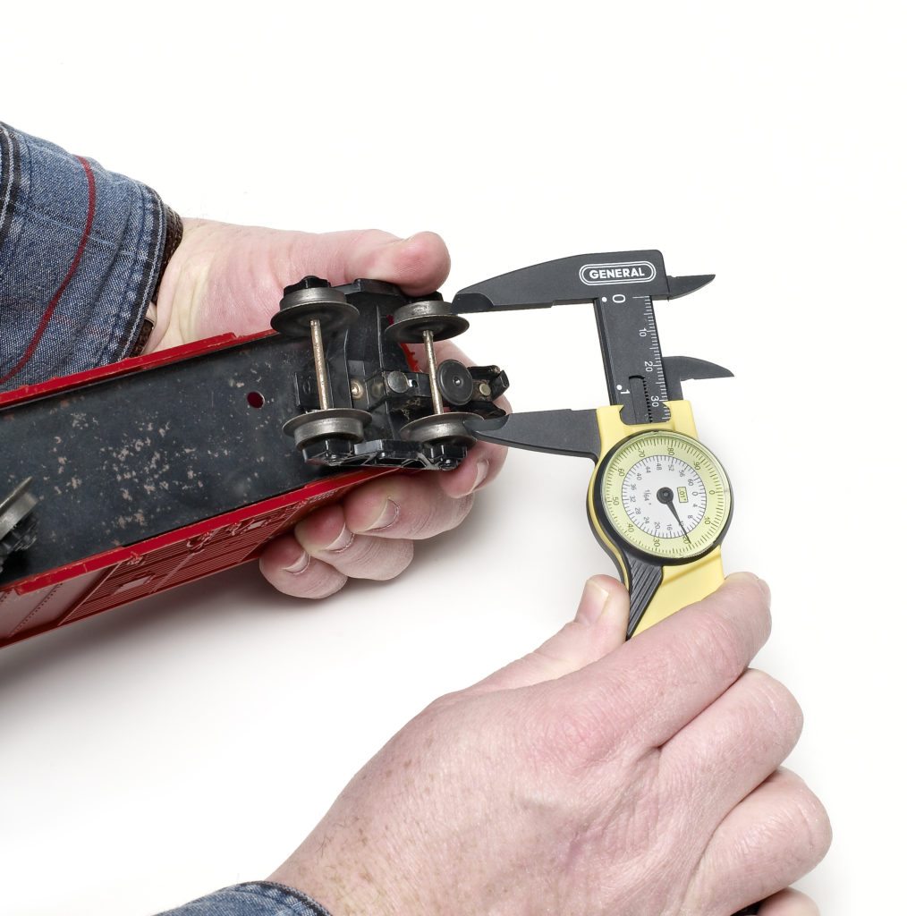 hand measuring wheel gauge on toy train