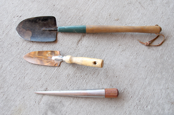 three weeding tools on concrete