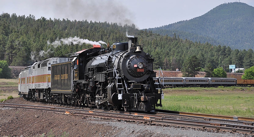 Steam locomotive and diesel helper rounding the curve on an excursion.