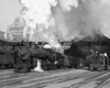 a steam passenger train leaving a station