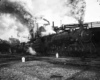 A black and white photo of a train with a lot of smoke coming out of its chimney