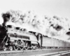 A black and white photo of a train with a lot of white smoke coming out of it