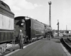 A black and white photo of a train parked with a conductor outside of it