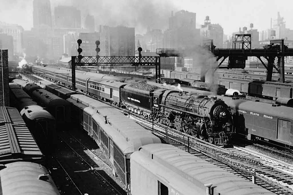 Steam passenger train departing a station