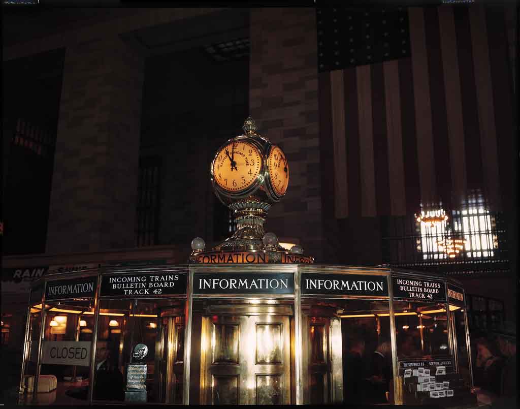An information booth with a lit up clock over it