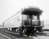 a conductor standing in front of an observation car