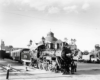 Steam locomotive with passenger train passes crossing gate watchman