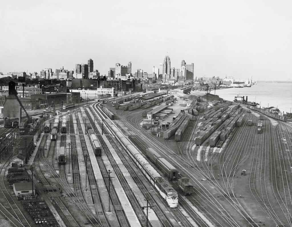 a large train yard with Detroit skyline in the background