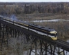 a diesel passenger train crossing a tall bridgea bridge