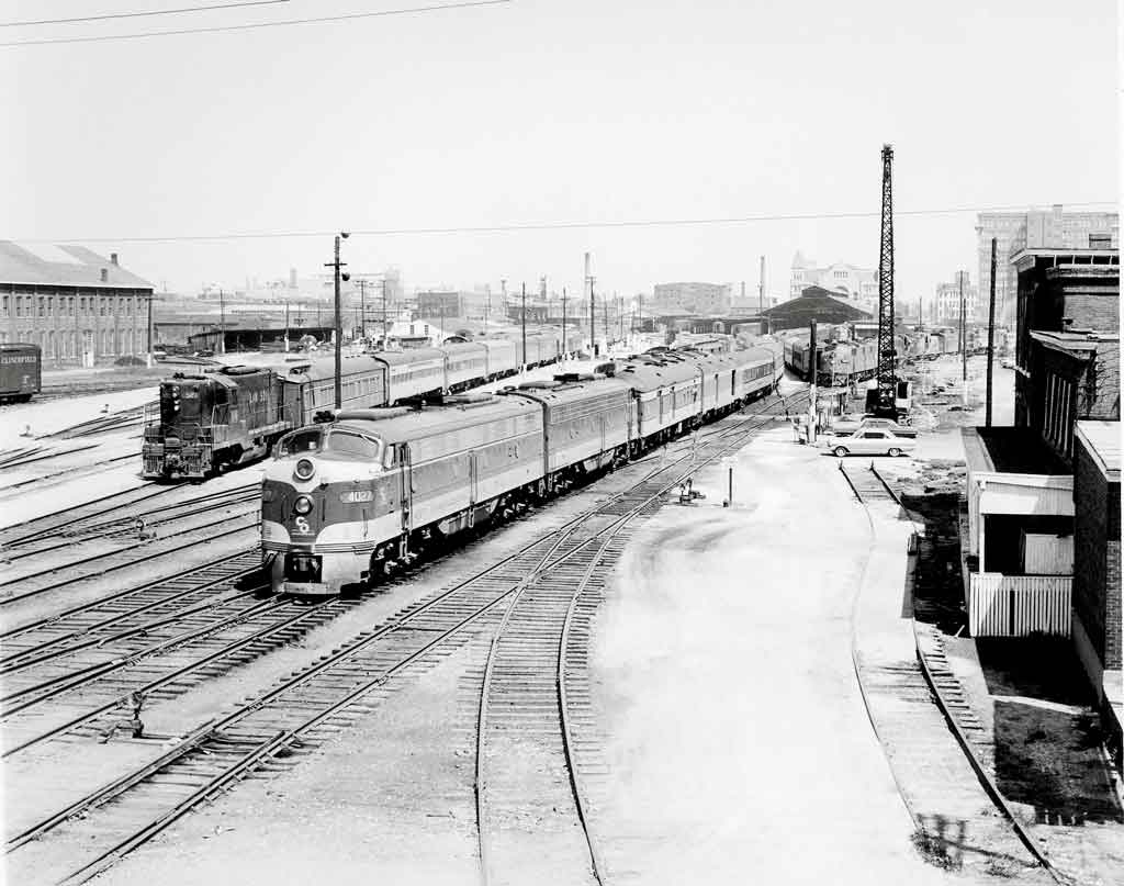 a couple of diesel passenger trains leaving a station
