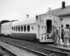 a group of people inspecting a passenger car with circular windows