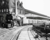 a steam engine sitting next to a train station