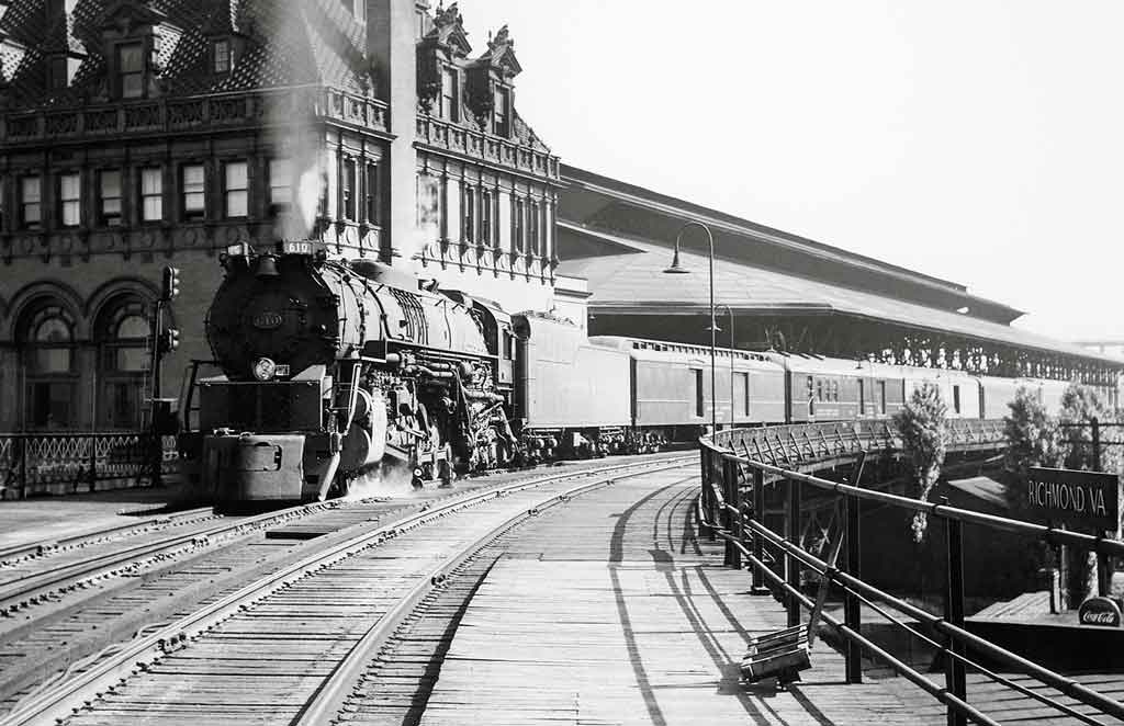 a steam engine sitting next to a train station