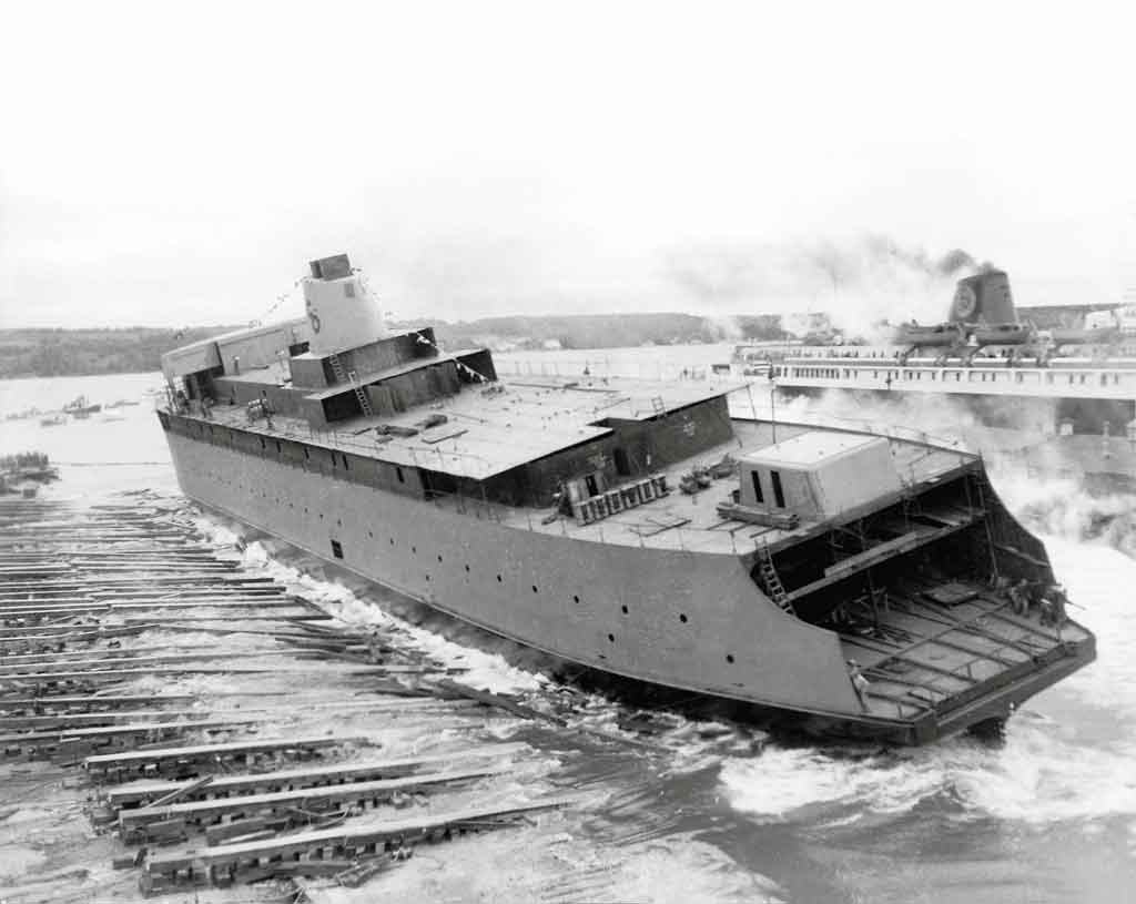 a large carferry sliding down long planks and splashing into watre