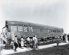 A black and white photo of passengers getting off a locomotive