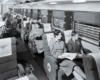 A black and white photo of the passengers sitting inside a train