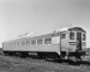 A black and white photo of a diesel car sitting on the tracks