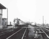 A black and white photo of two locomotives leaving a station