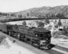 A black and white photo of a locomotive turning a corner