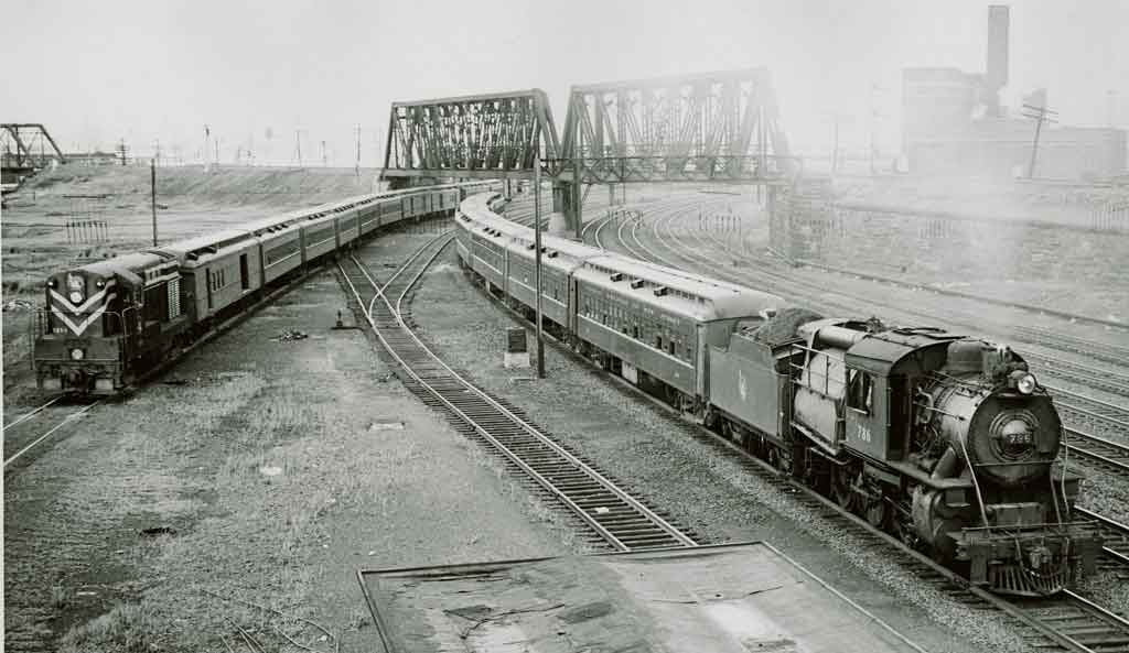 A black and white photo of two locomotives stemming off in different directions