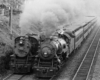 A black and white picture of two trains running side by side